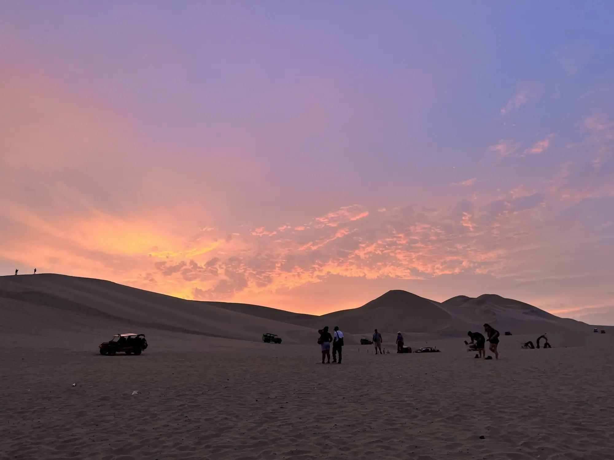 Cielo rosado del atardecer sobre las dunas del desierto de Ica