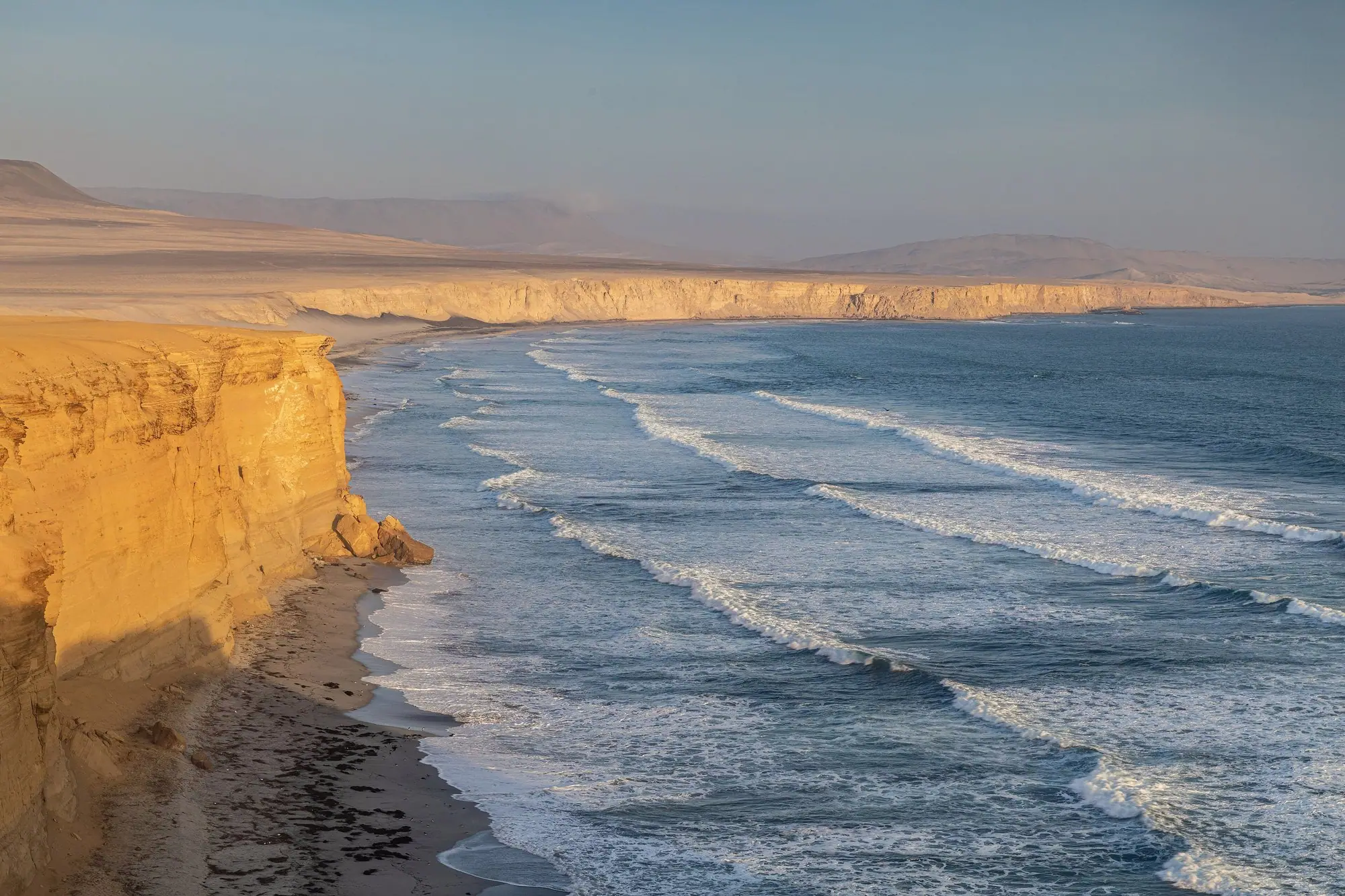 Acantilados dorados de Paracas iluminados por la luz del atardecer